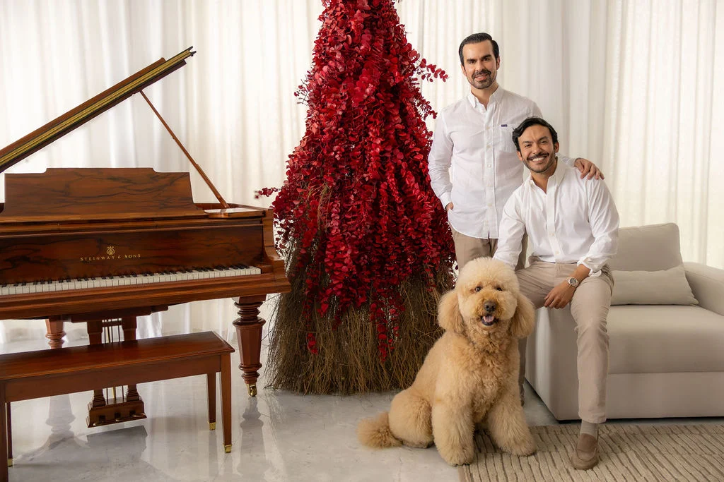 Familia con su perro frente a un árbol de Navidad