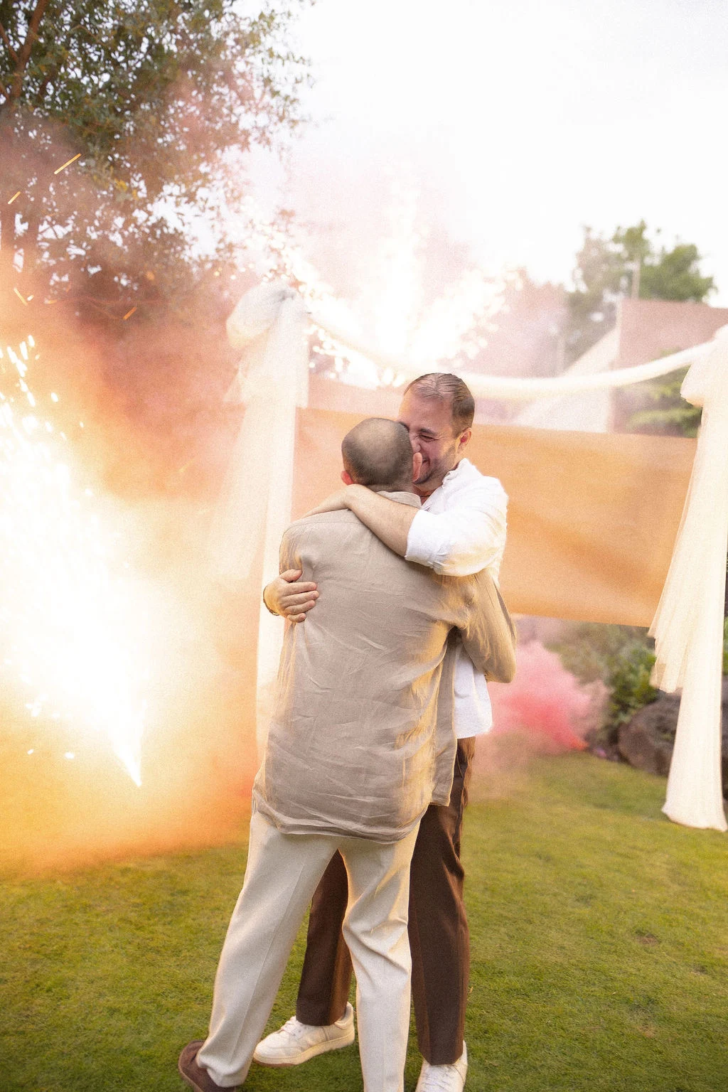 Pareja abrazándose entre humo de colores en una celebración