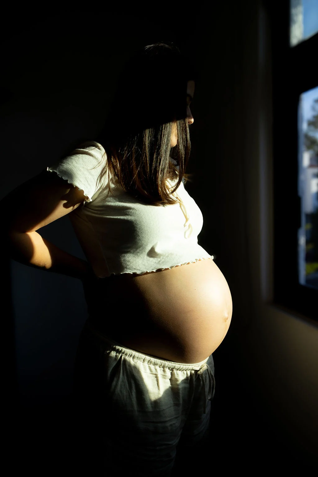 Retrato de embarazo iluminado por una ventana